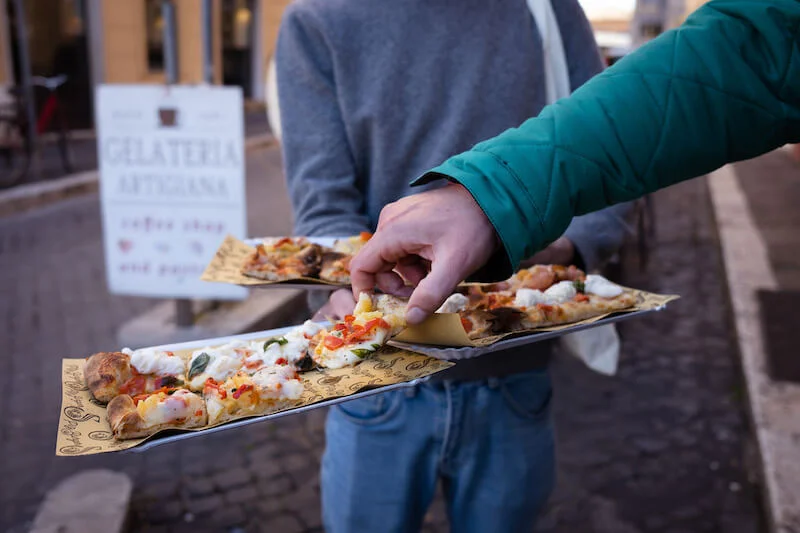 Enjoying traditional pizza al taglio on a Trastevere Food Tour